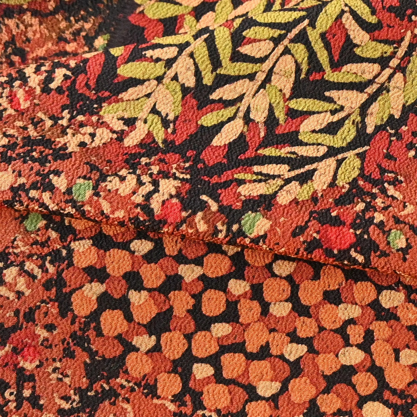 Detailed view of vintage Japanese autumn colour palette heavy silk crepe kimono fabric with a botanical pattern.