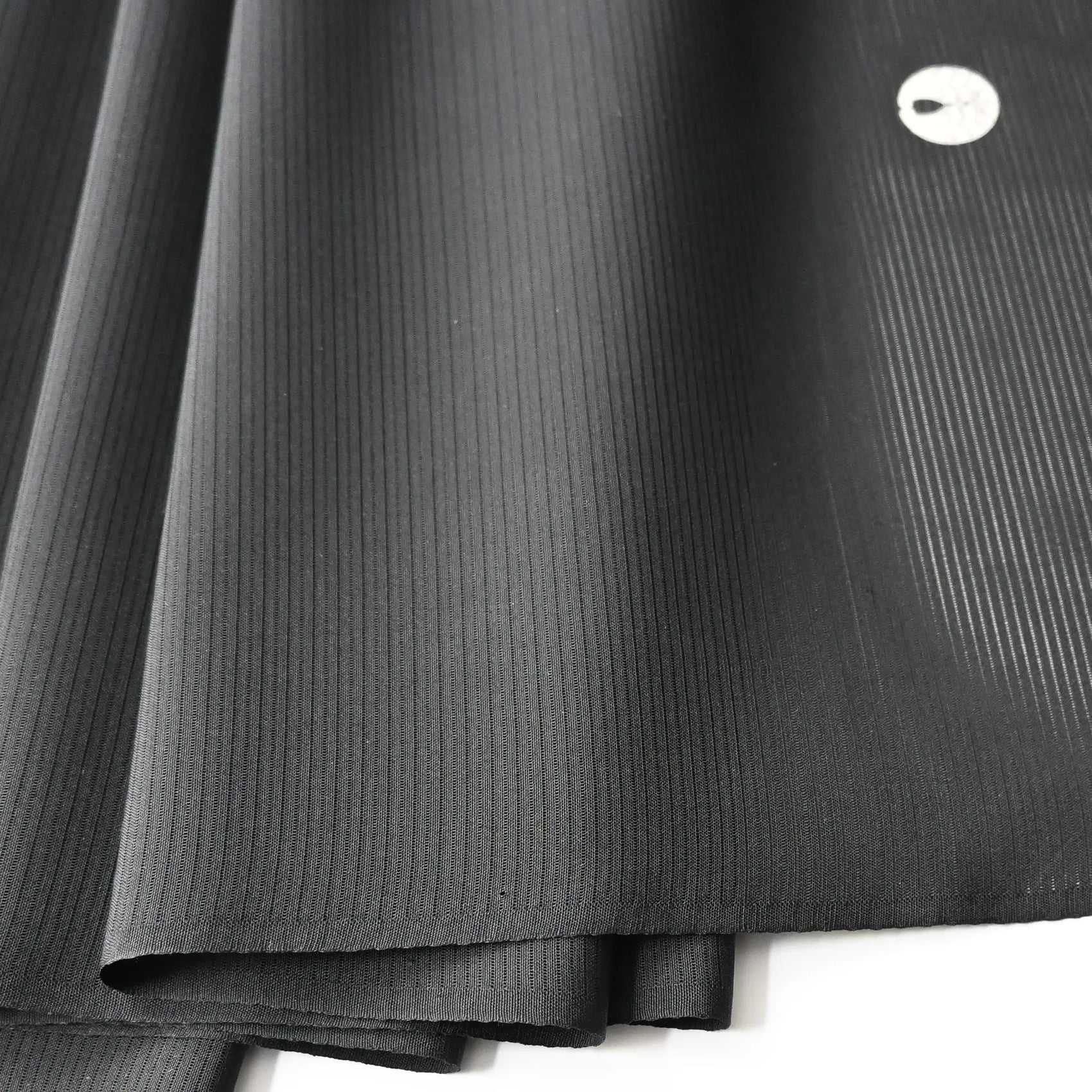 Detailed view of vintage Japanese plain black Ro silk kimono bolt.