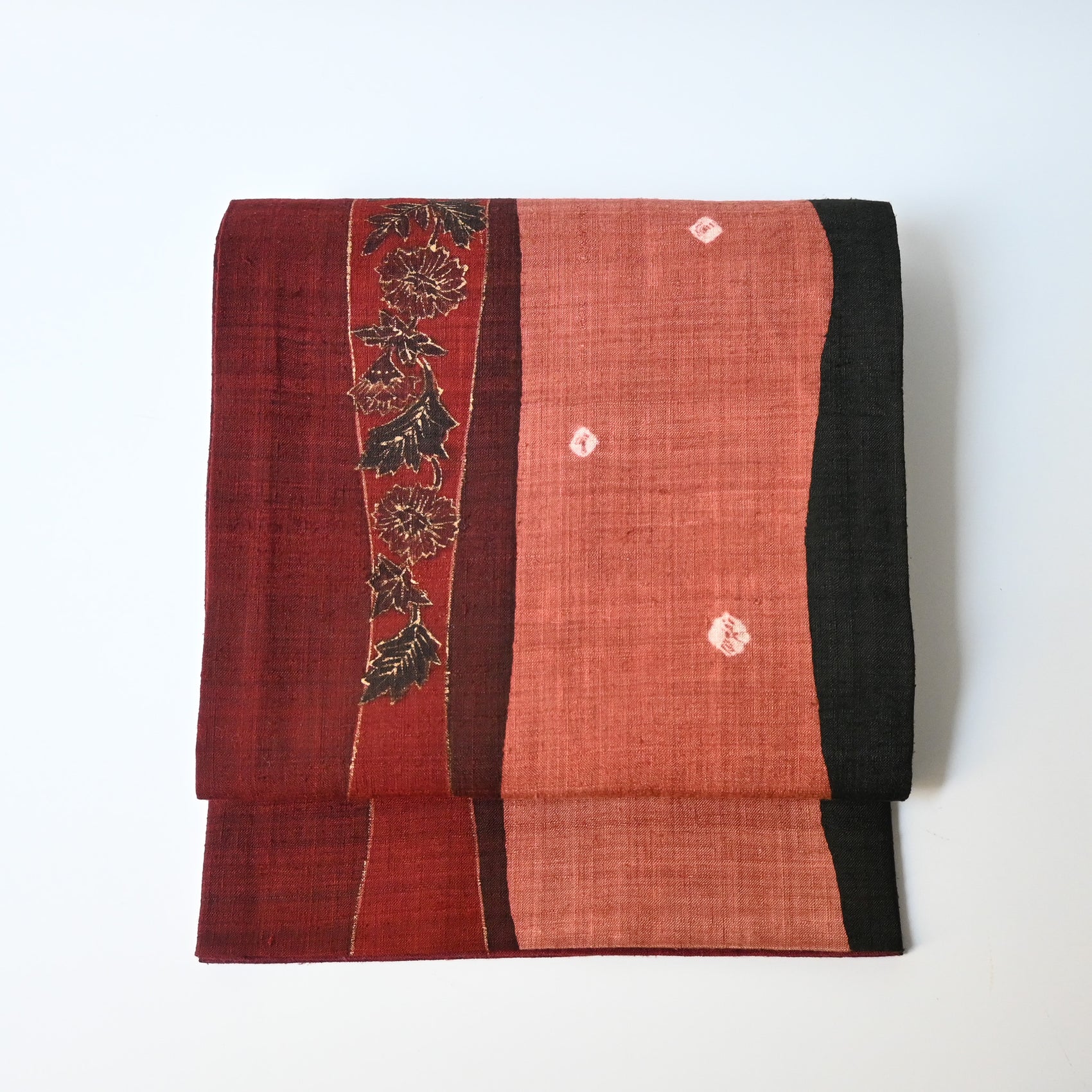 Vintage Japanese tsumugi silk fukuro obi in burgundy red with botanical design.