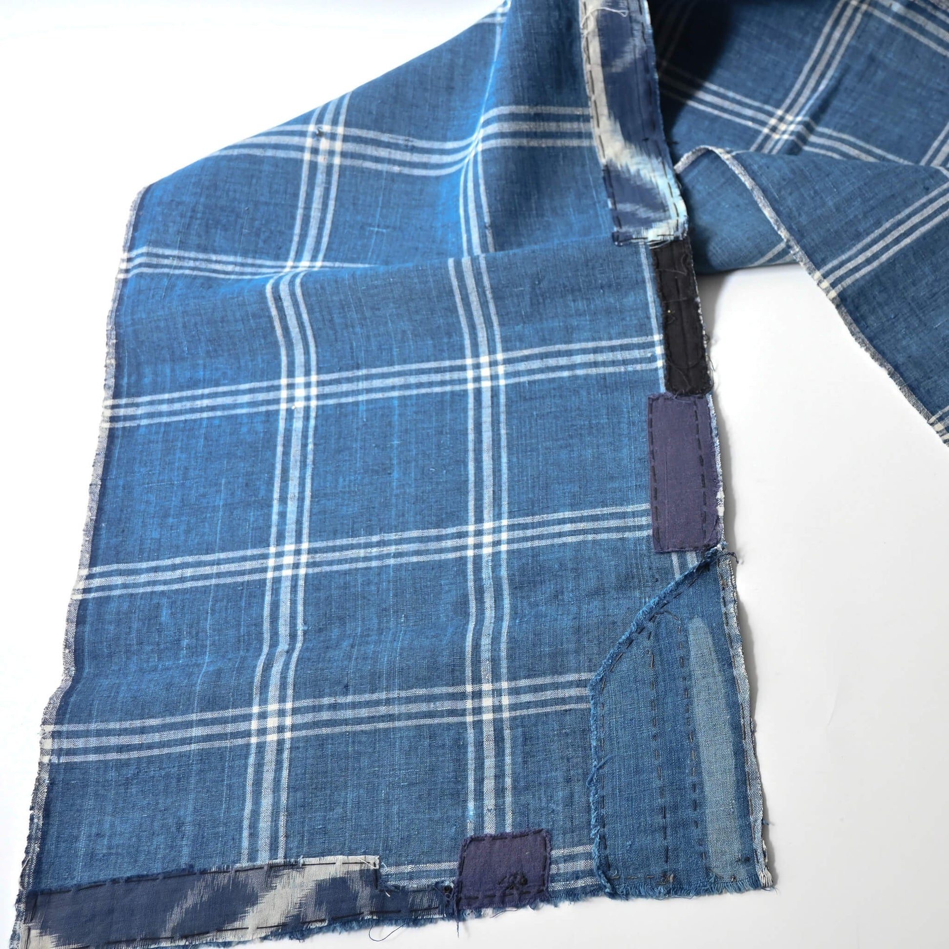 Detailed view of vintage Japanese indigo check cotton, boro mended piece from an old futon cover.