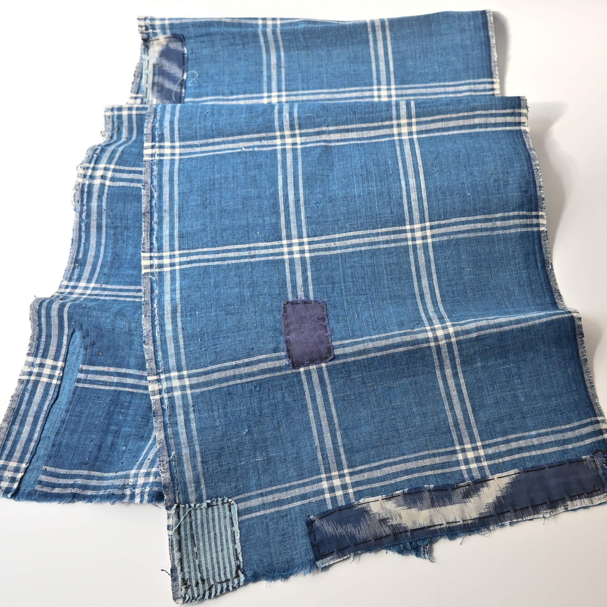 Detailed view of vintage Japanese indigo check cotton, boro mended piece from an old futon cover.