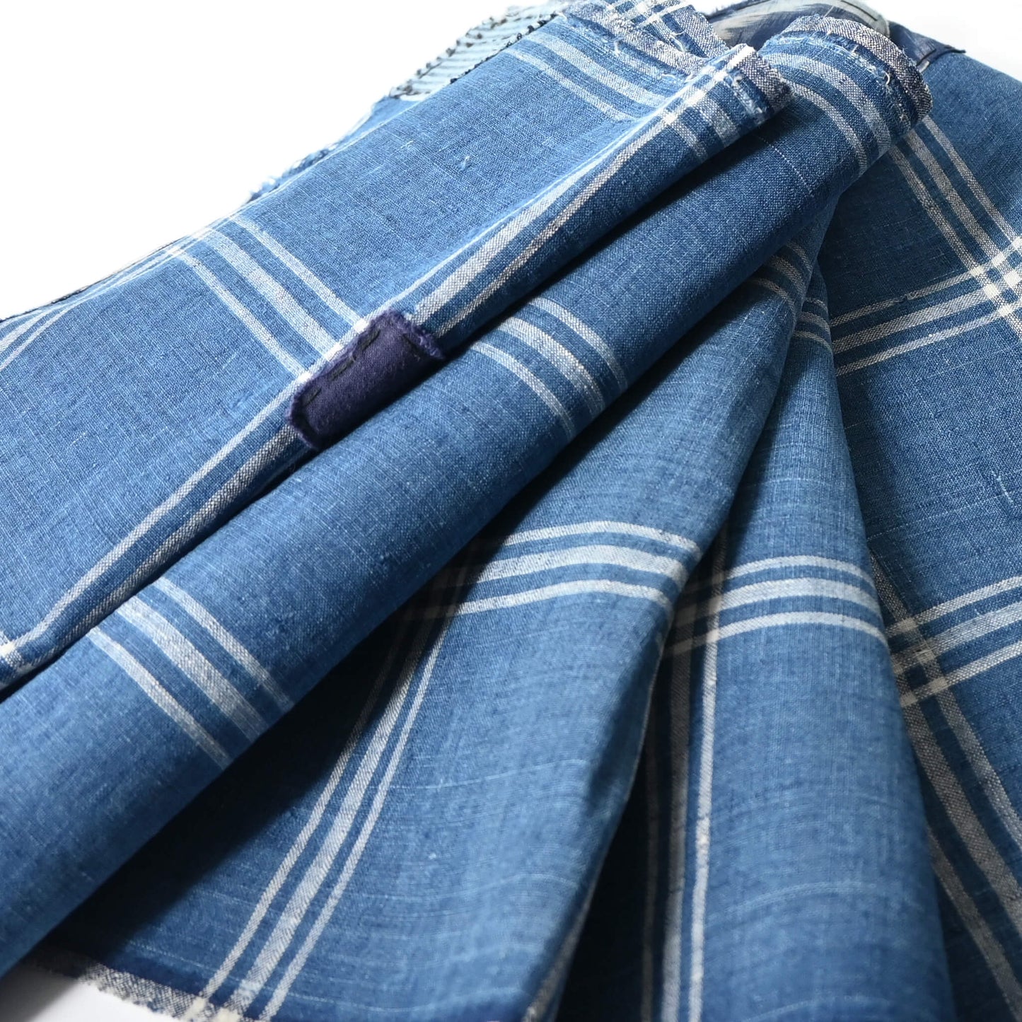 Close-up view of vintage Japanese indigo check cotton, boro mended piece from an old futon cover.