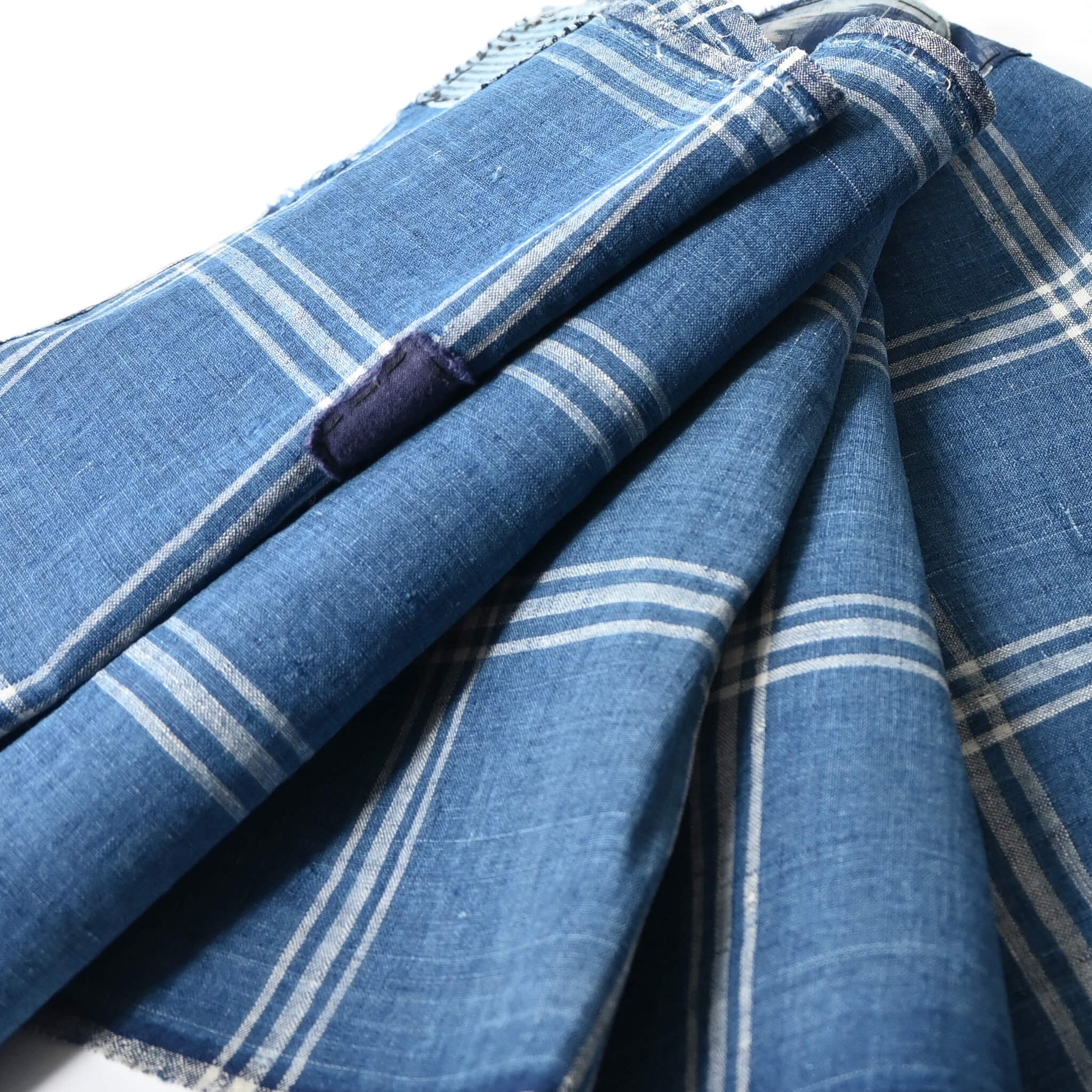 Close-up view of vintage Japanese indigo check cotton, boro mended piece from an old futon cover.