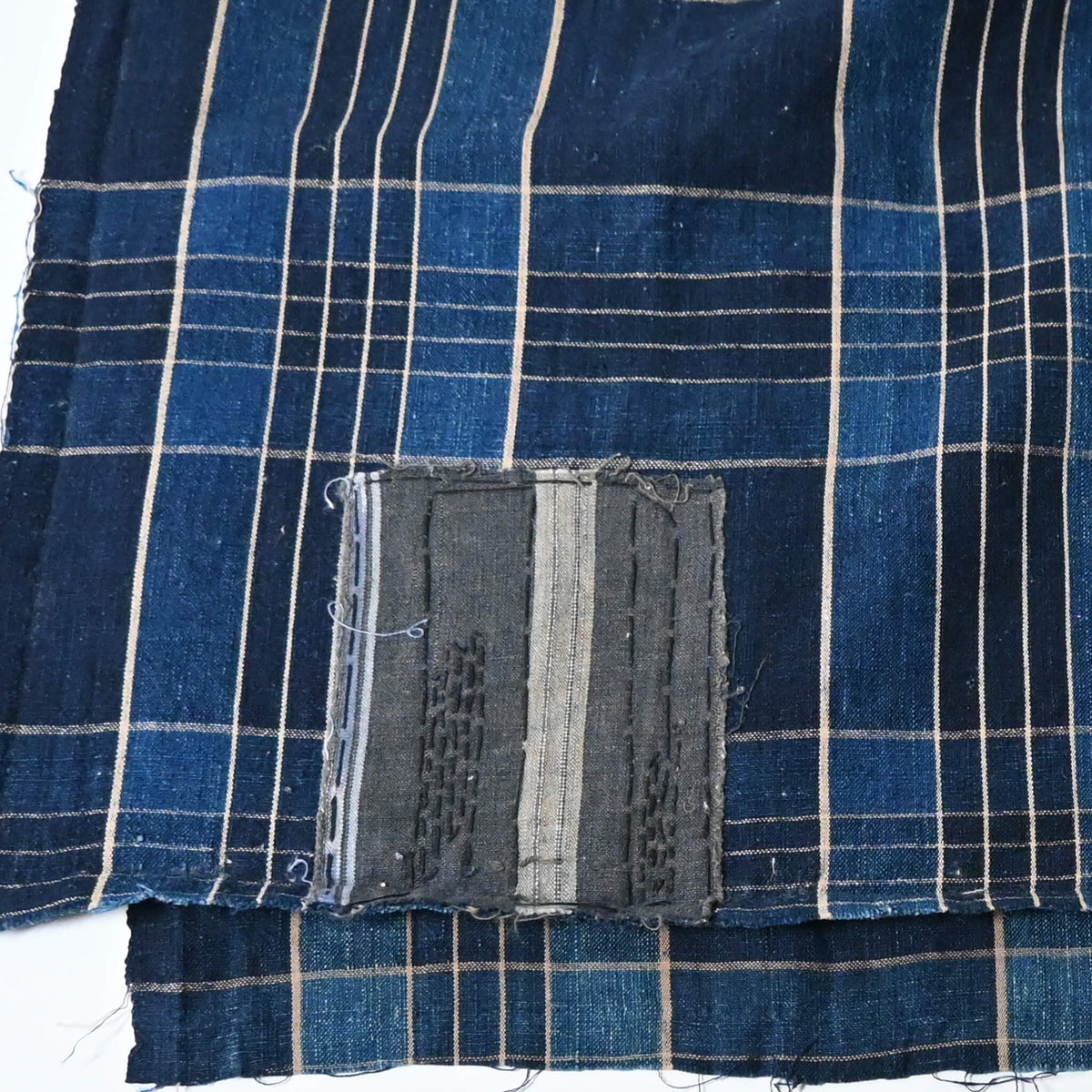 Close-up view of vintage Japanese indigo check cotton piece from old futon cover with mend.