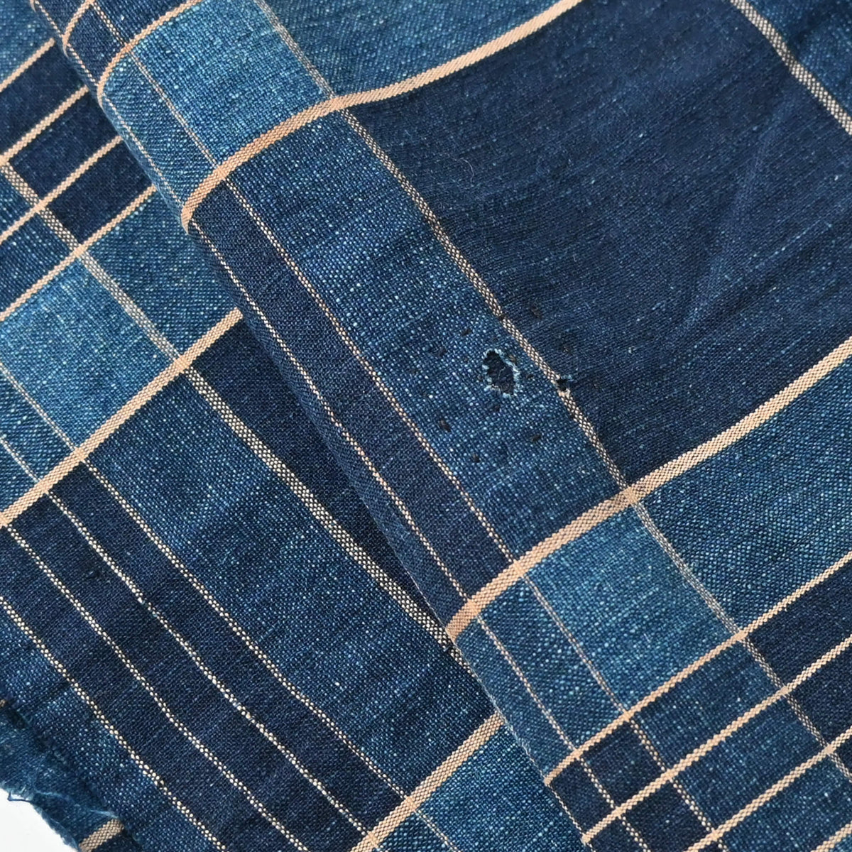 Close-up view of vintage Japanese indigo check cotton piece from old futon cover with mend.