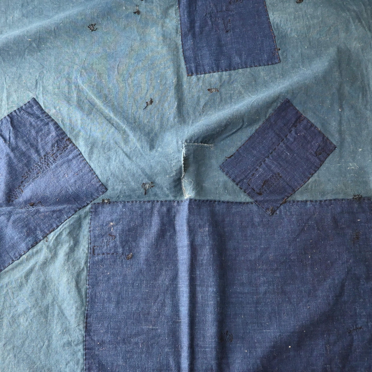 Vintage Japanese indigo cotton furoshiki with various hand-stitched mends, family crest and surname are dyed at corners.