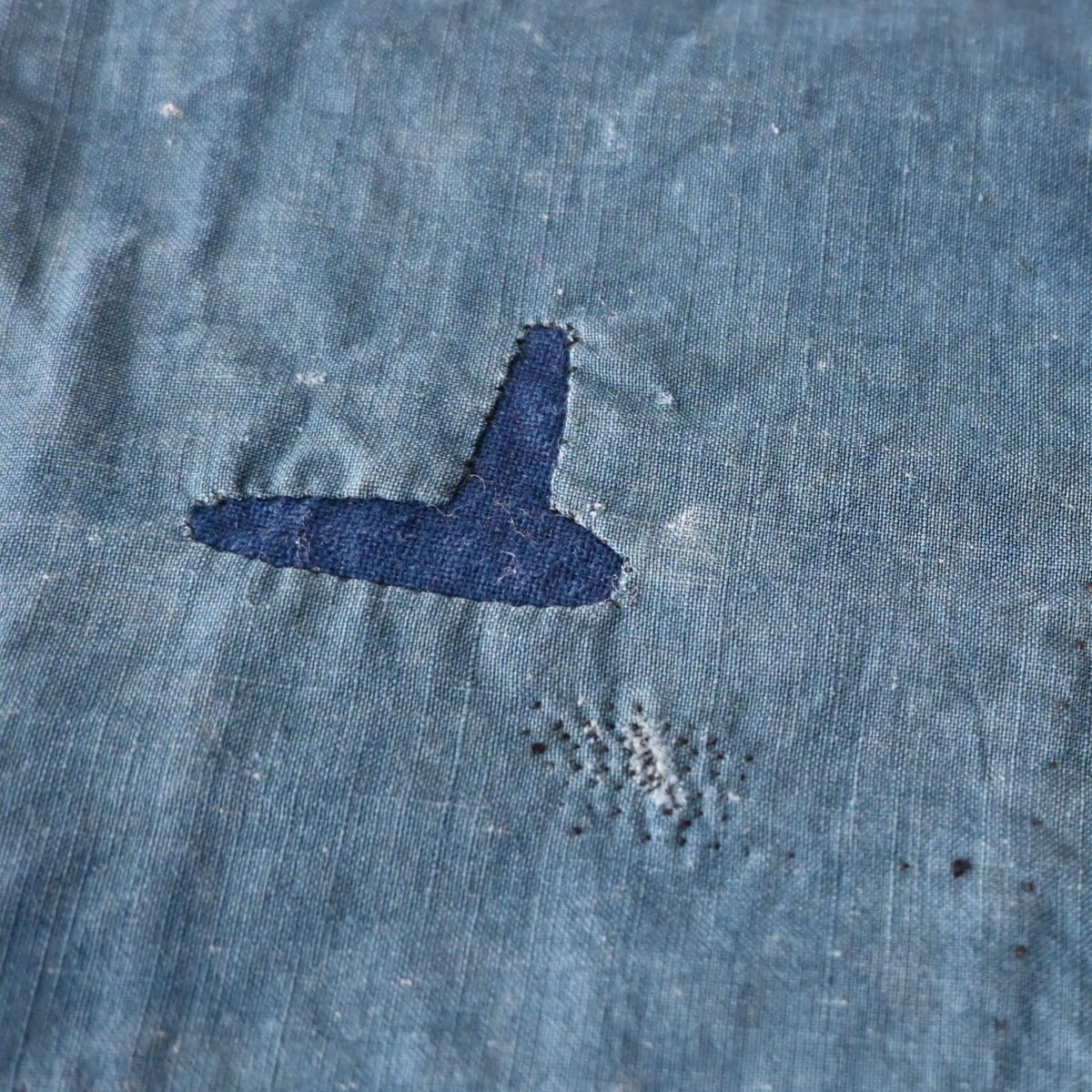 Detailed view of vintage Japanese indigo cotton furoshiki with various hand-stitched mends.