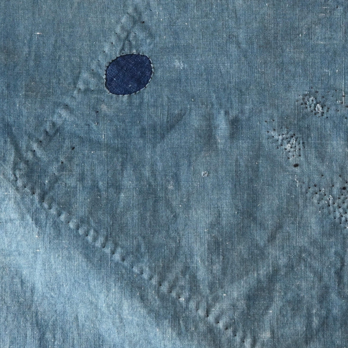 Detailed view of vintage Japanese indigo cotton furoshiki with various hand-stitched mends.