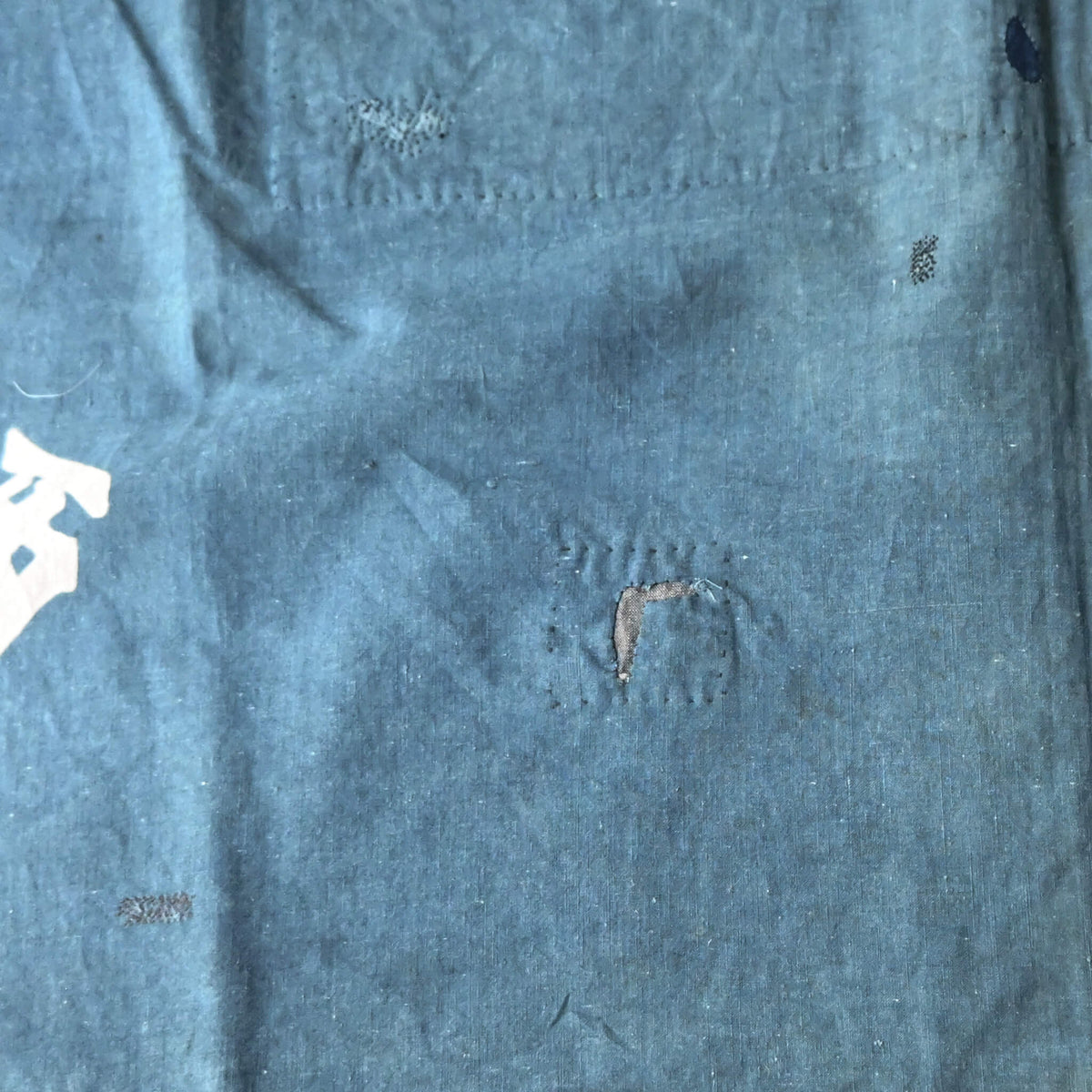 Detailed view of vintage Japanese indigo cotton furoshiki with various hand-stitched mends.