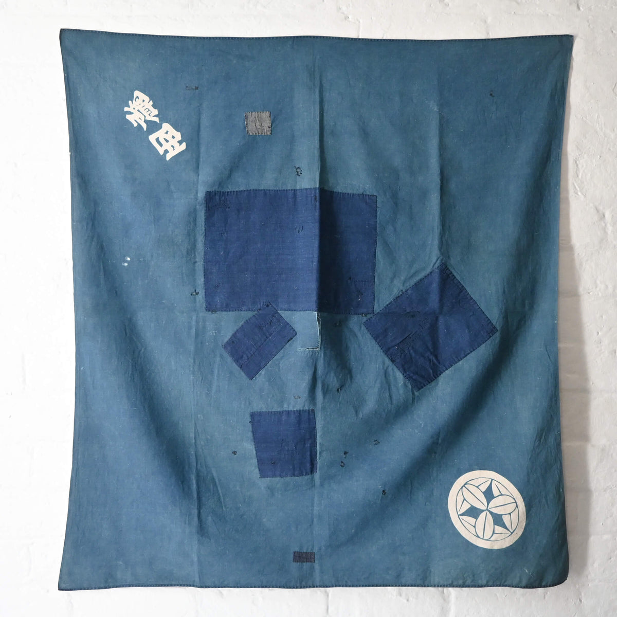 Vintage Japanese indigo cotton furoshiki with various hand-stitched mends, family crest and surname are dyed at corners.