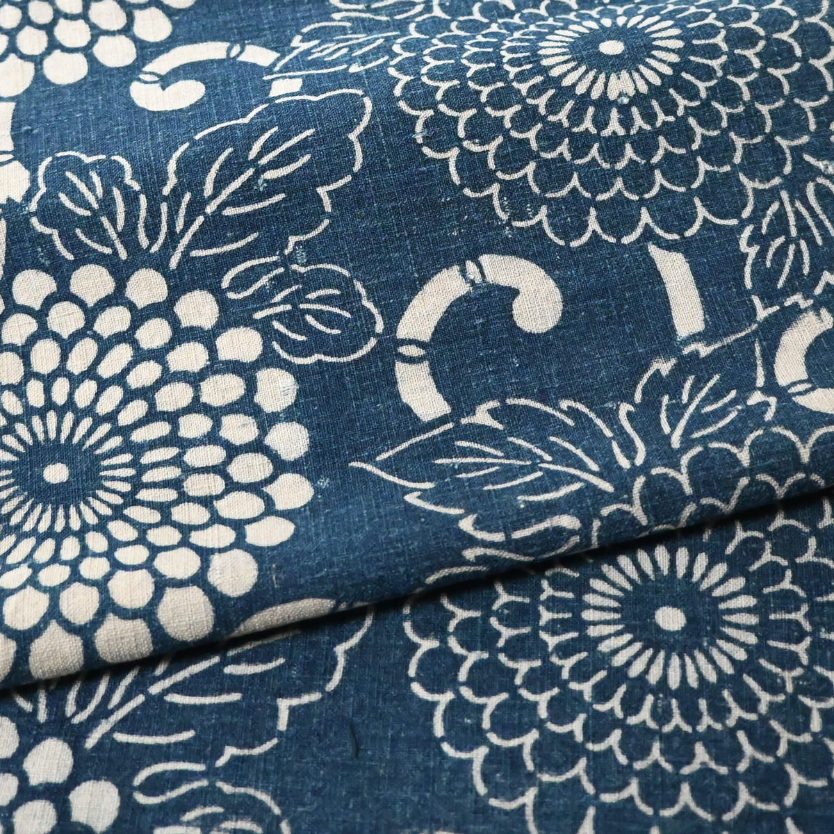 Close-up view of vintage Japanese indigo Katazome dyed cotton with chrysanthemum karakusa motif from the early 20th C.