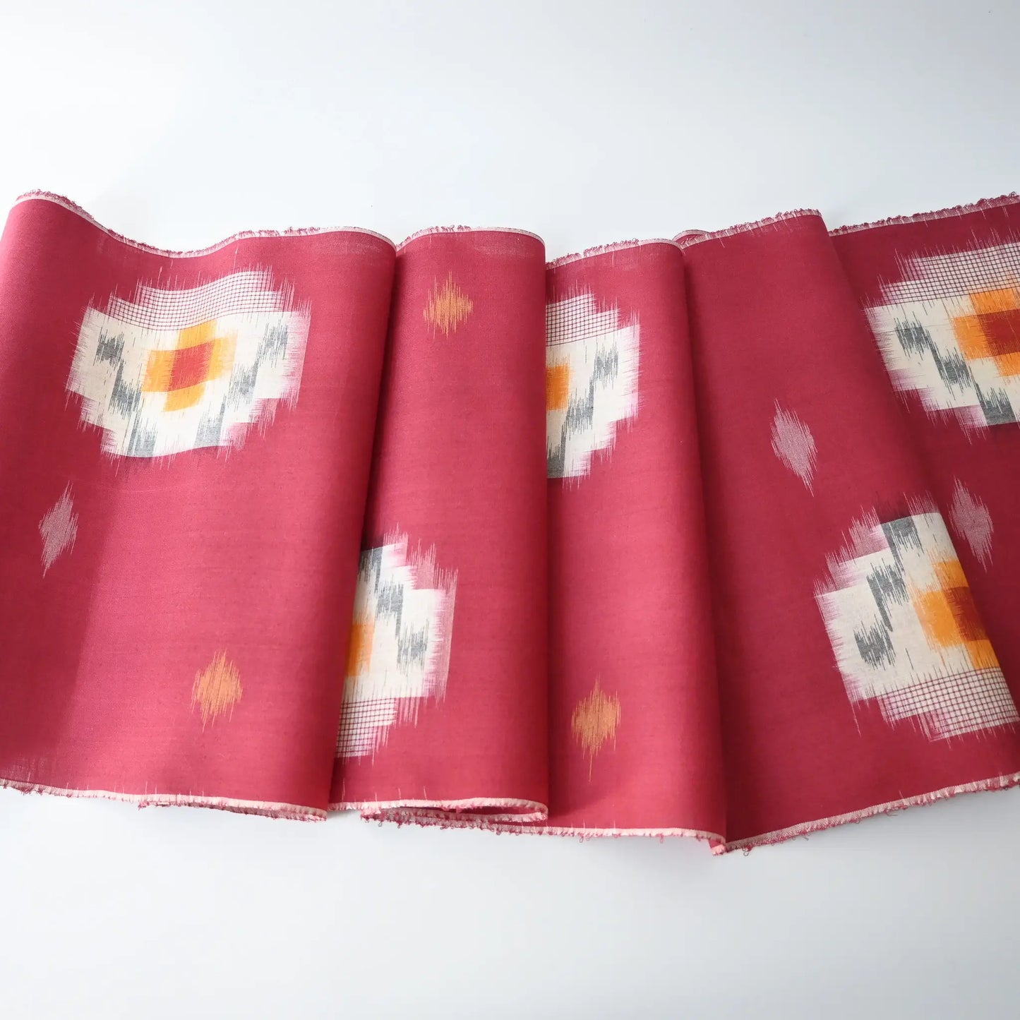 Vintage Japanese kasuri cotton kimono fabric roll in raspberry pink with a bold pattern from the mid 20th century.
