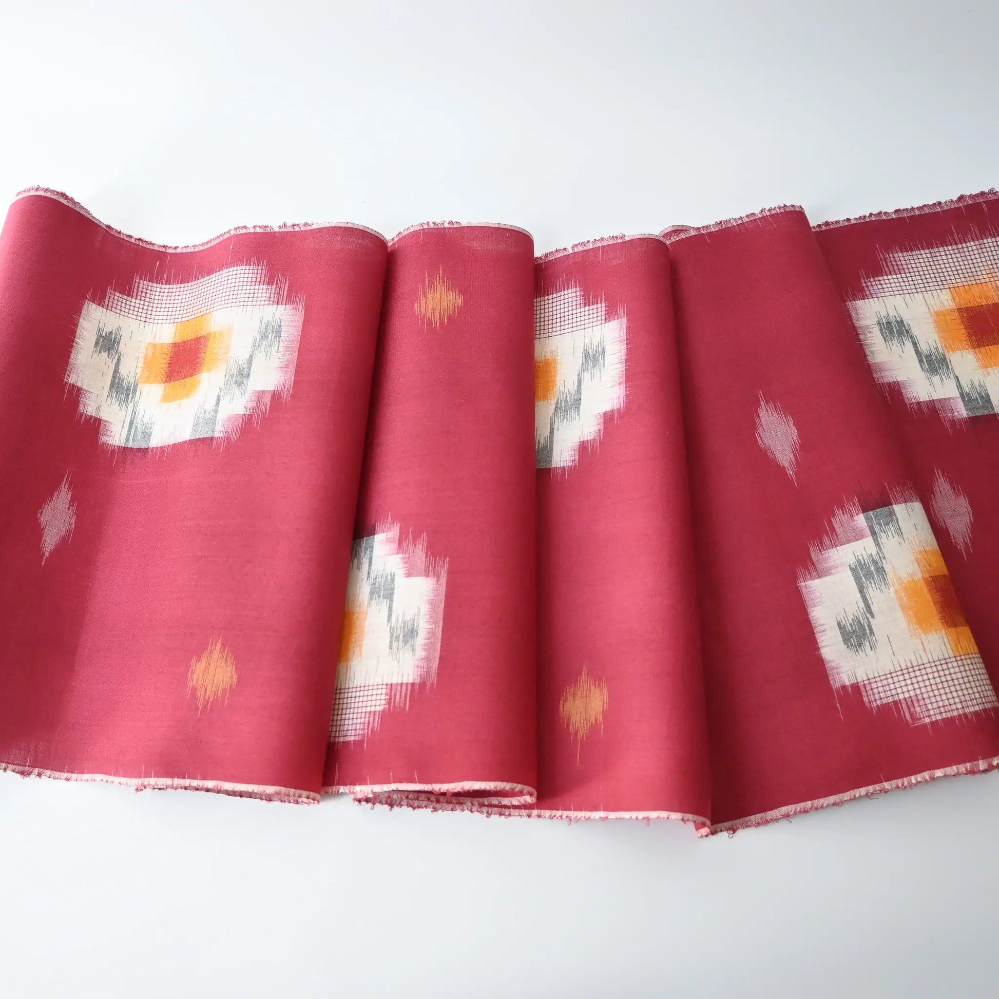 Vintage Japanese kasuri cotton kimono fabric roll in raspberry pink with a bold pattern from the mid 20th century.