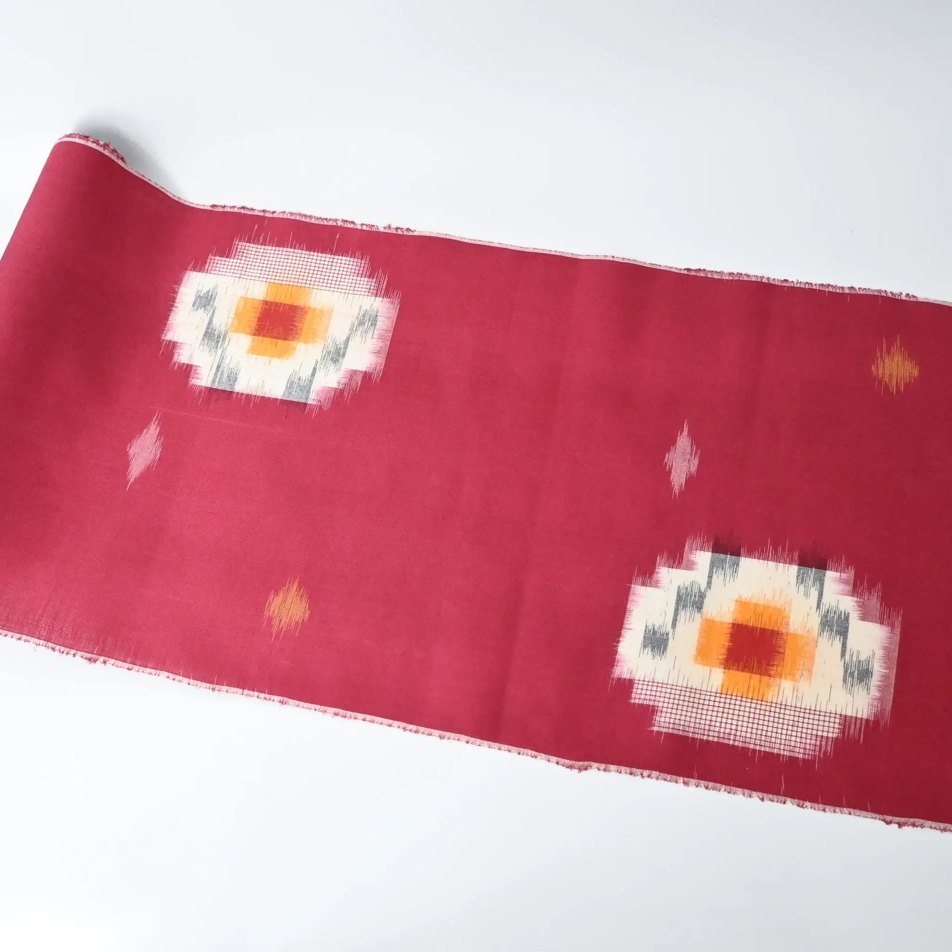 Vintage Japanese kasuri cotton kimono fabric roll in raspberry pink with a bold pattern from the mid 20th century.