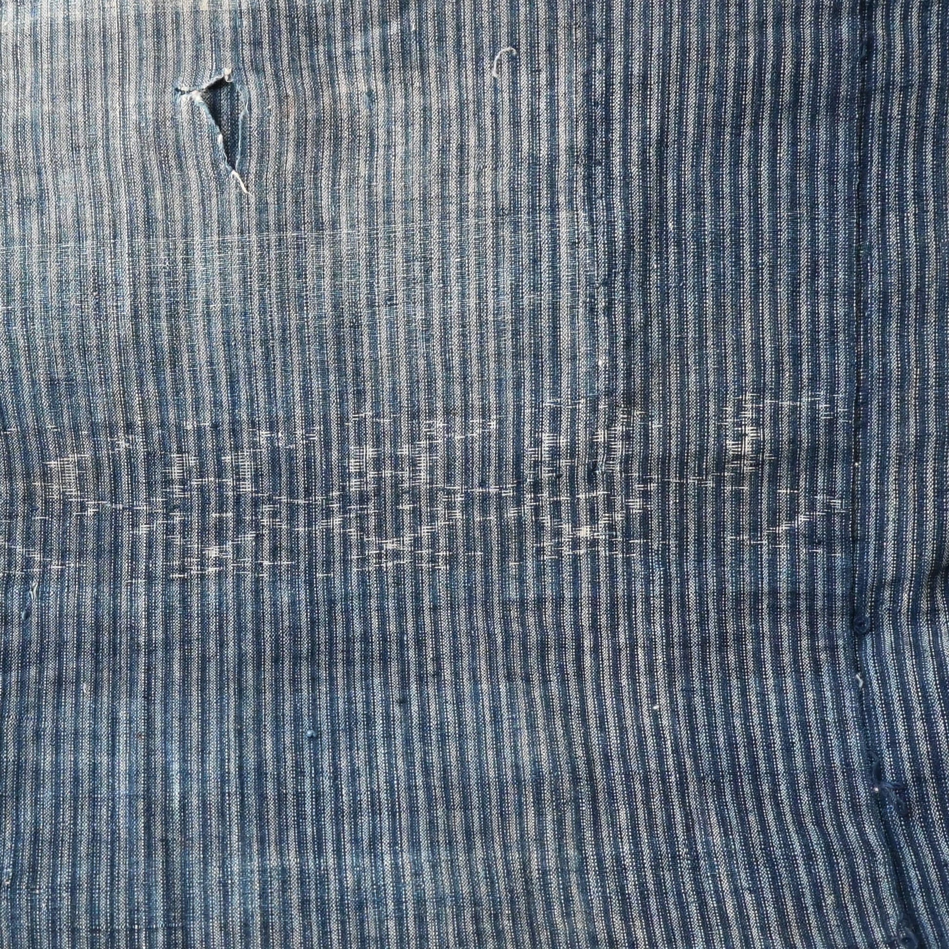 Vintage indigo stripe and Kasuri patterned cotton with a hole.