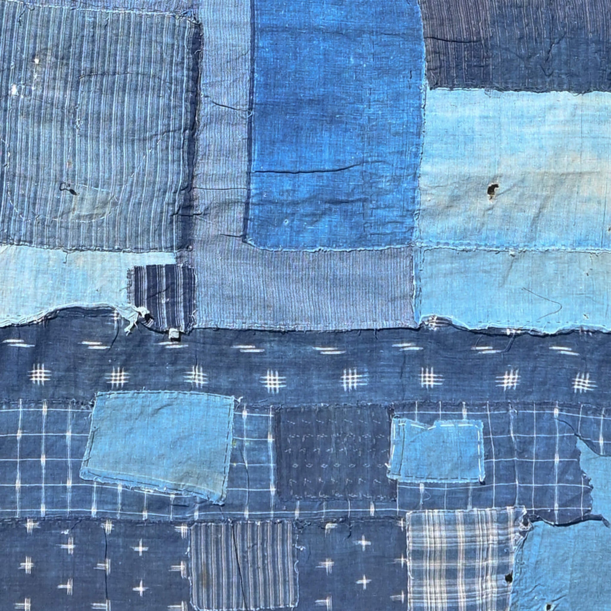 Section of vintage old Japanese Boro indigo cotton futon cover with lots of patches, showcasing Kasuri cotton pieces.