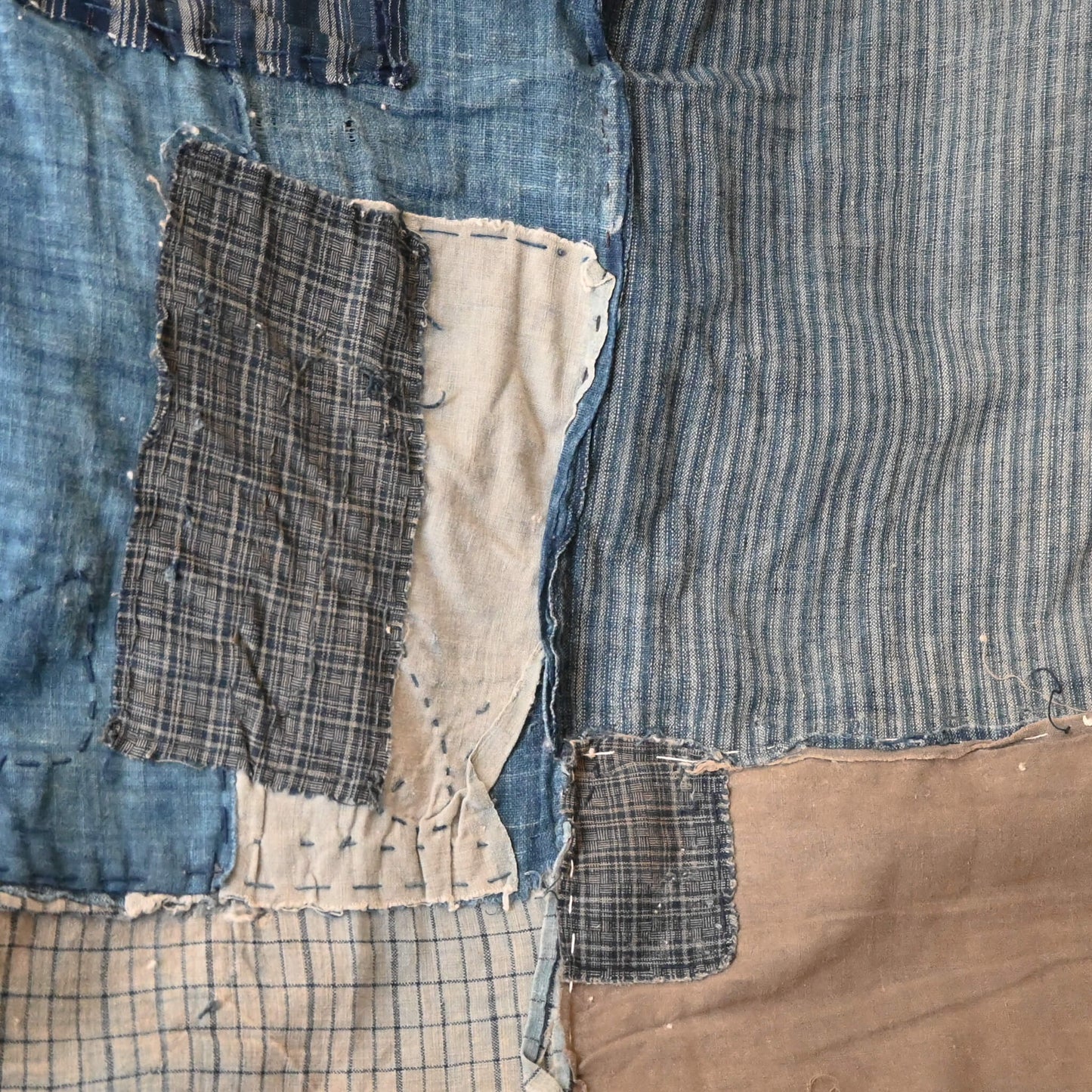 Various different small indigo cotton pieces stitched together.