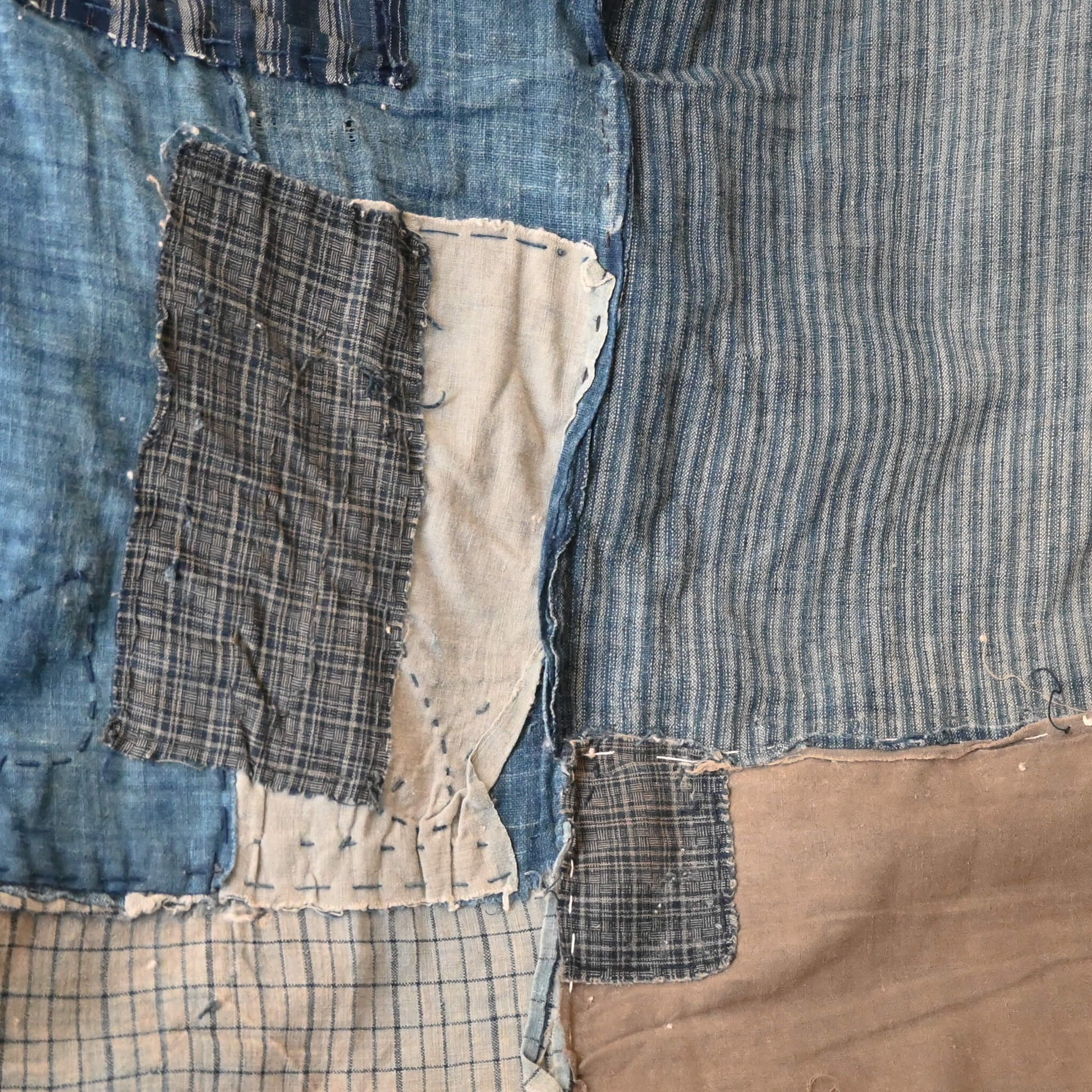 Various different small indigo cotton pieces stitched together.