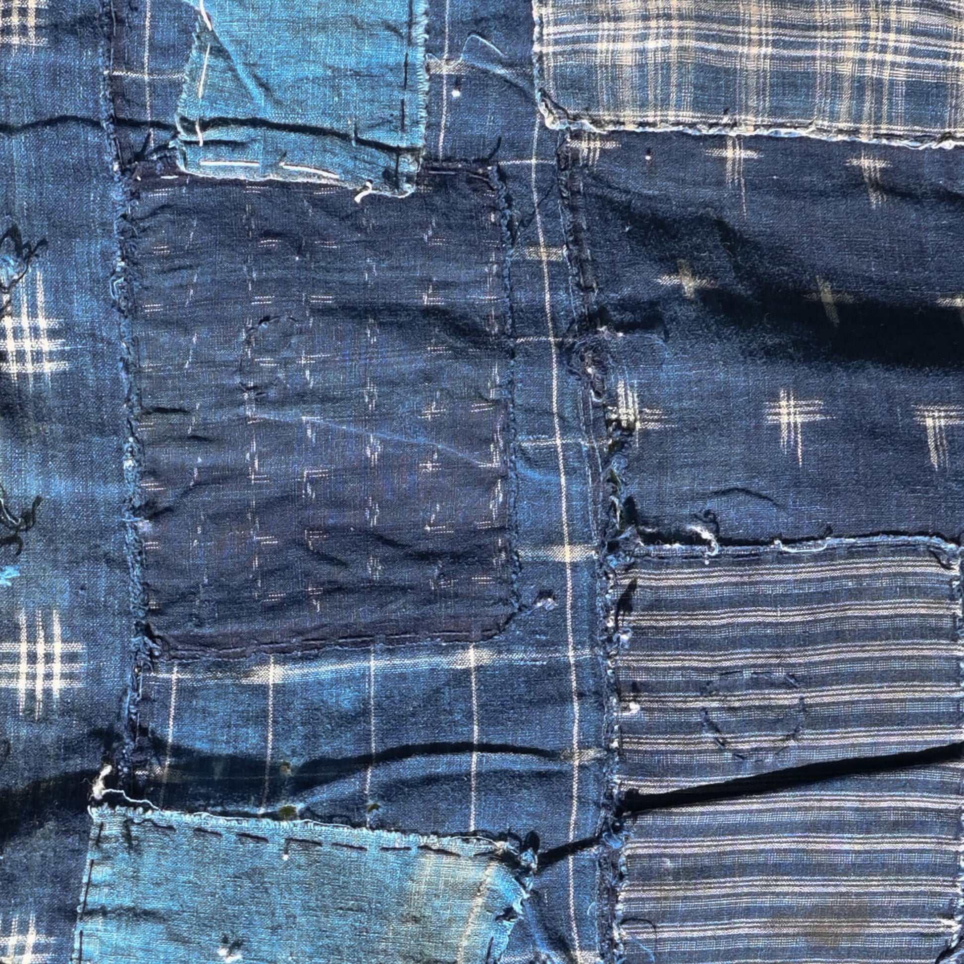 Vintage Japanese indigo Kasuri cottons with mending stitches.