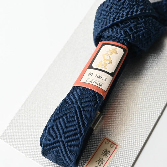 Close-up view of vintage/recycled men's haorihimo, silk braided cords in deep navy.