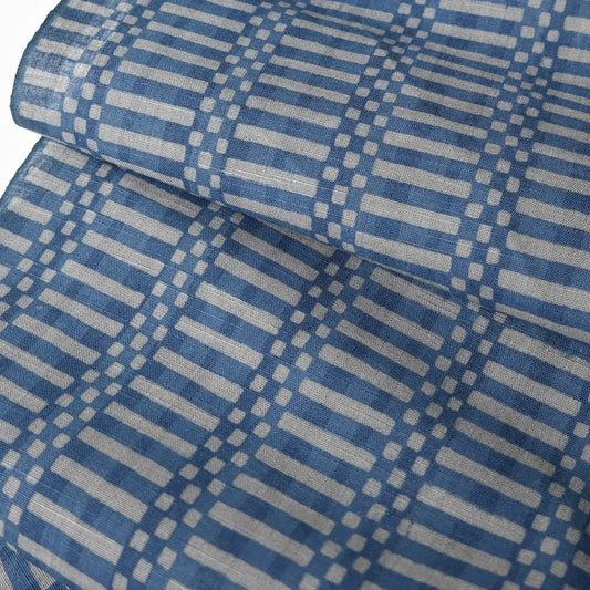 Close-up view of vintage Japanese men's yukata cotton fabric, soft blue and grey geometric check design, sold by the metre.