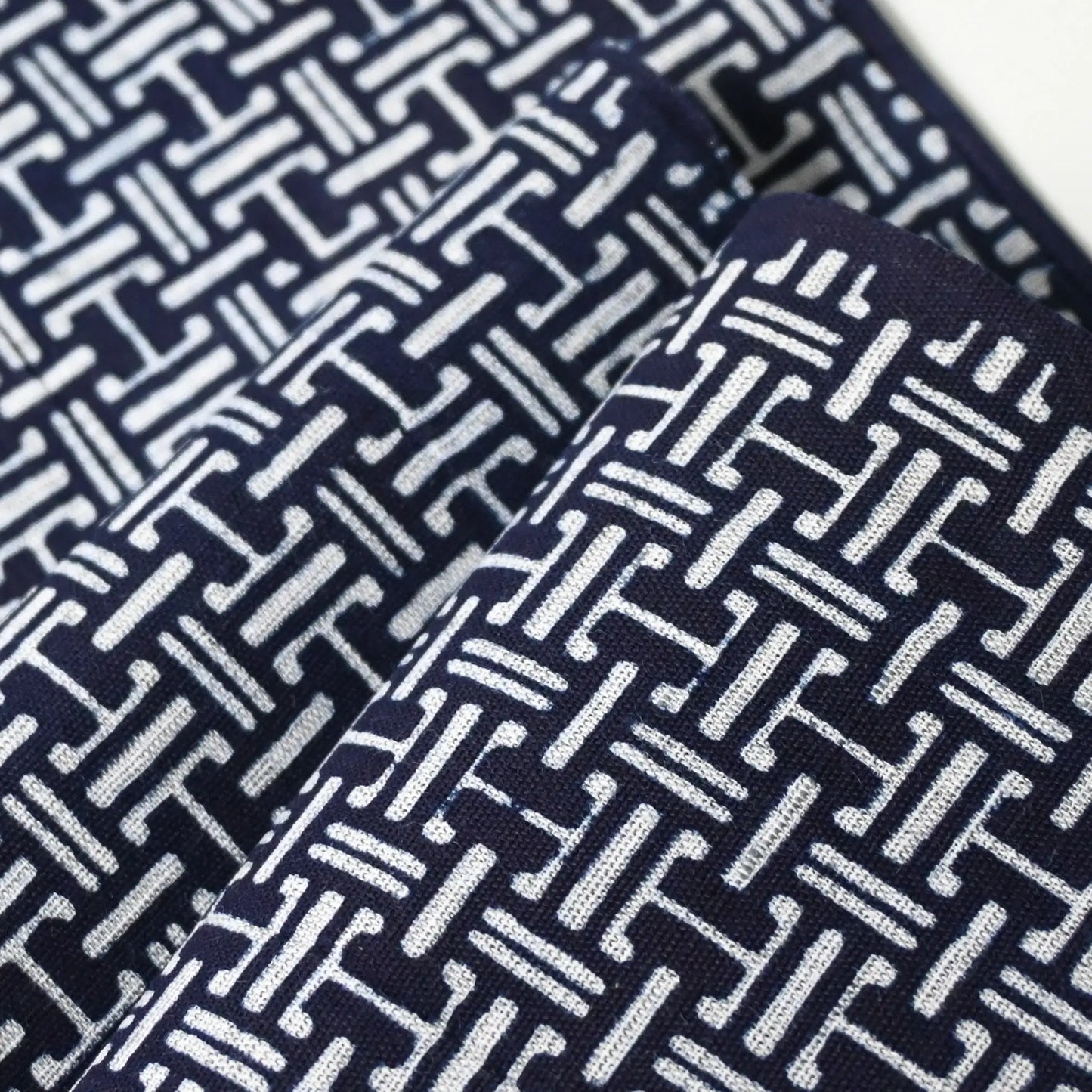 Close-up view of vintage Japanese men's yukata cotton fabric with geometric pattern, sold by the metre.