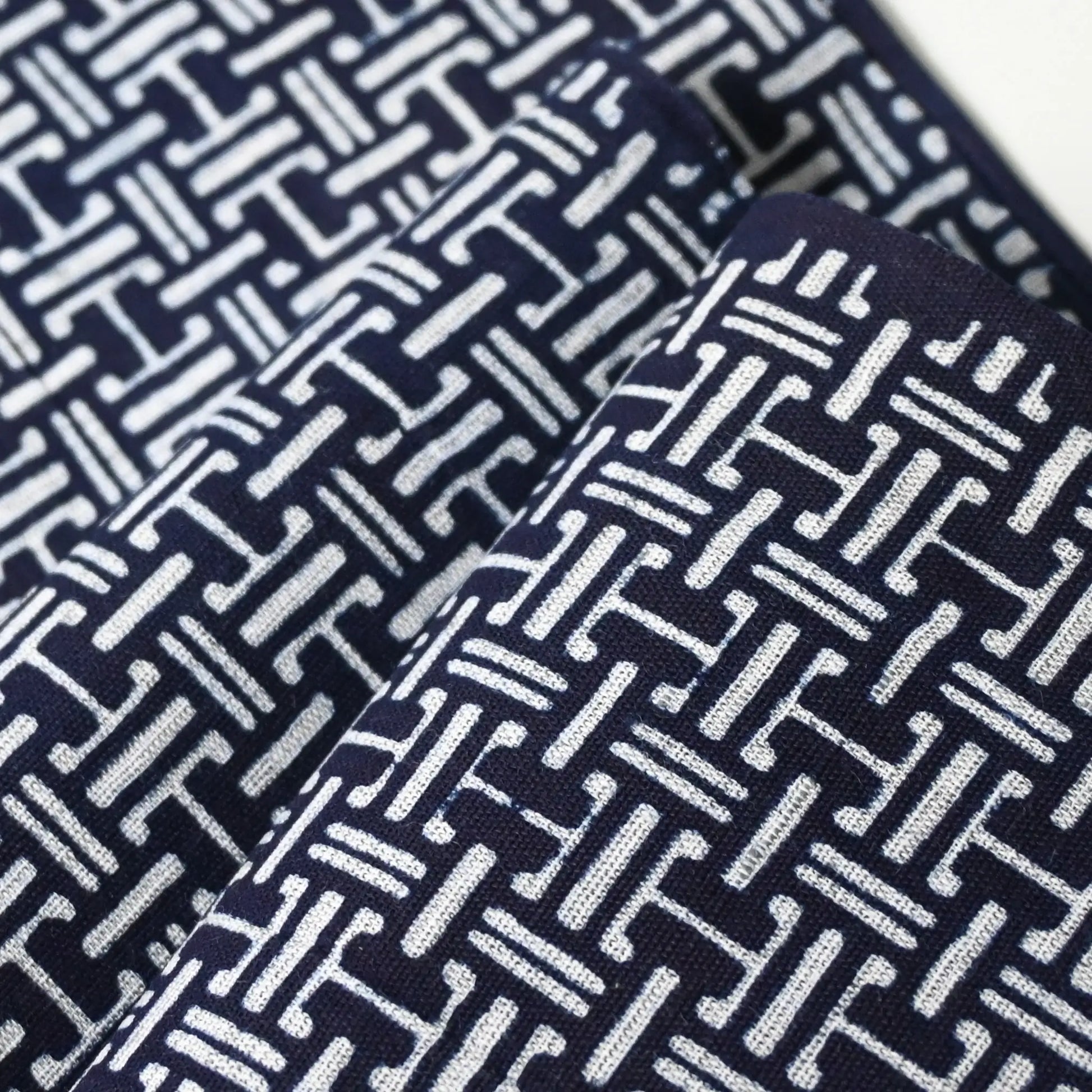 Close-up view of vintage Japanese men's yukata cotton fabric with geometric pattern, sold by the metre.