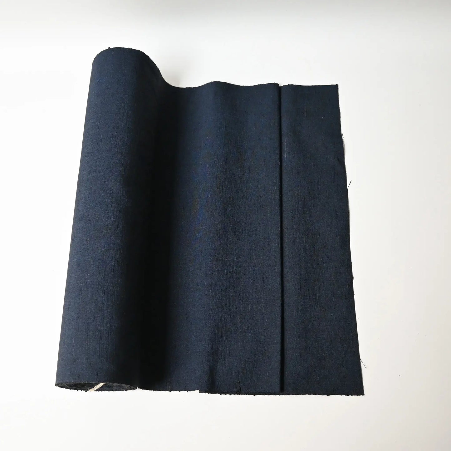 Vintage dead stock men's tsumugi silk kimono fabric roll in navy blue.