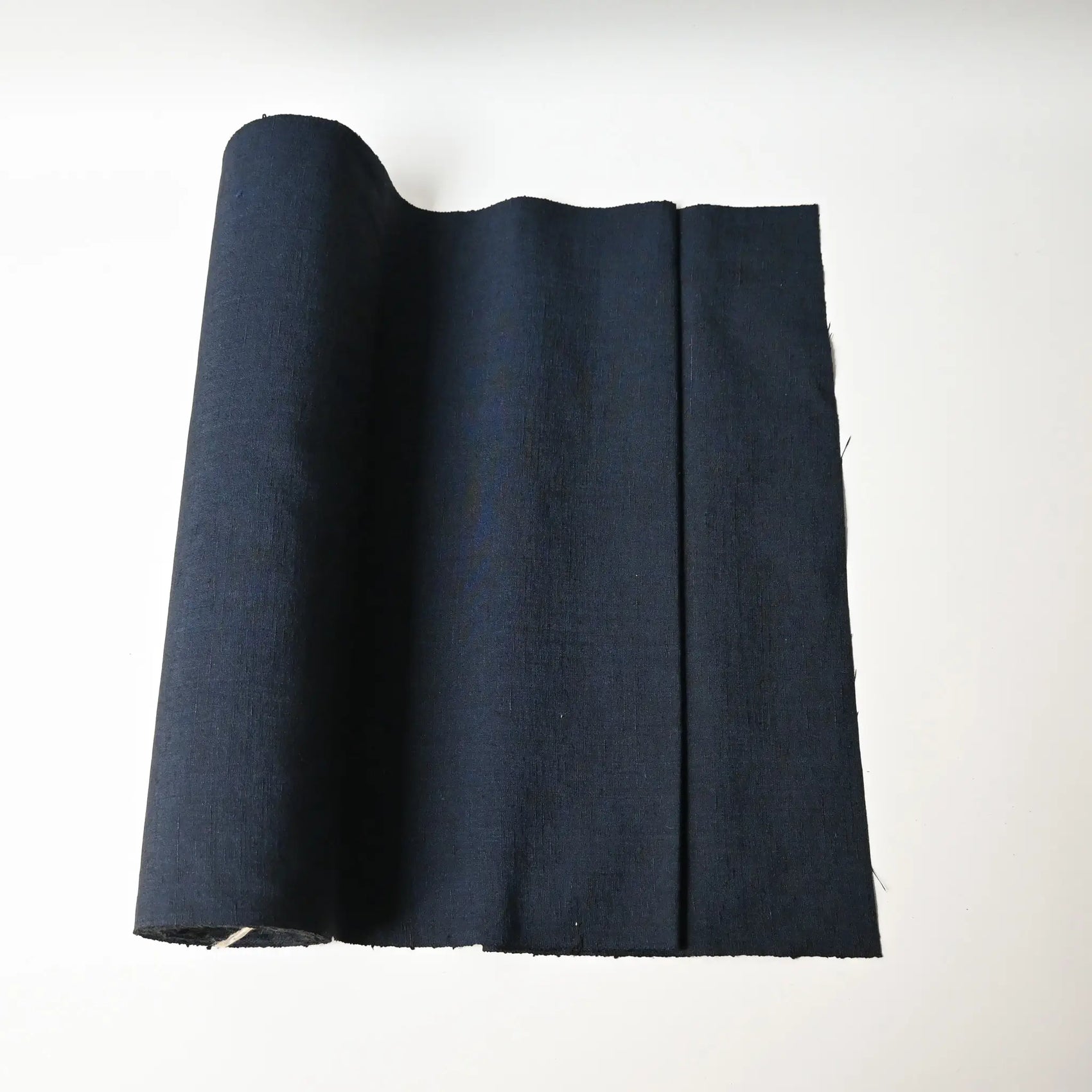 Vintage dead stock men's tsumugi silk kimono fabric roll in navy blue.