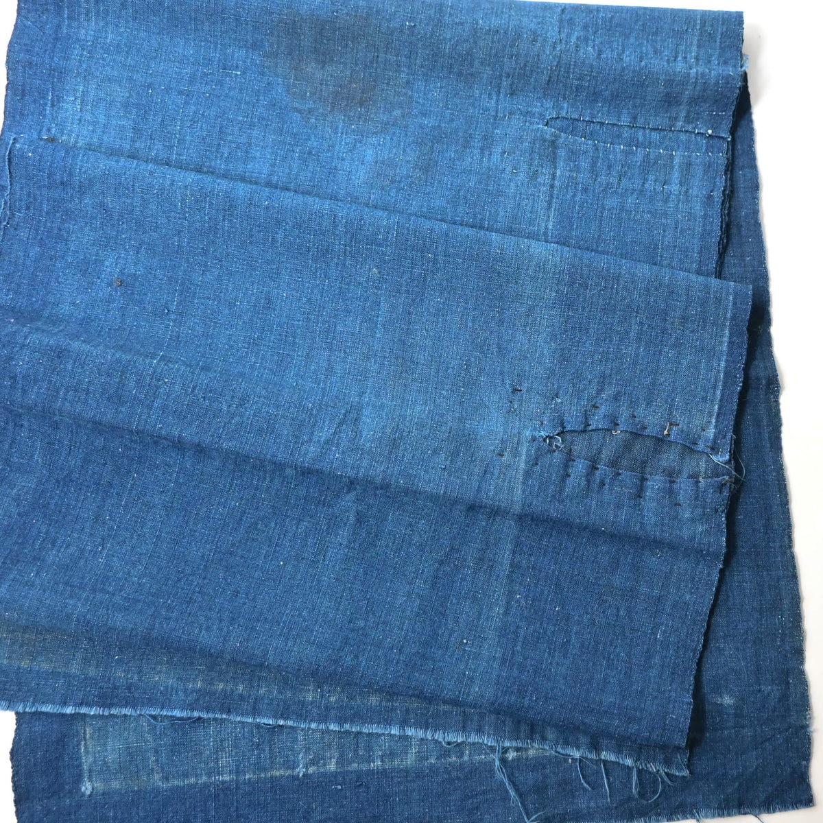 Detailed view of vintage Japanese plain indigo cotton from old kimono with some mends.