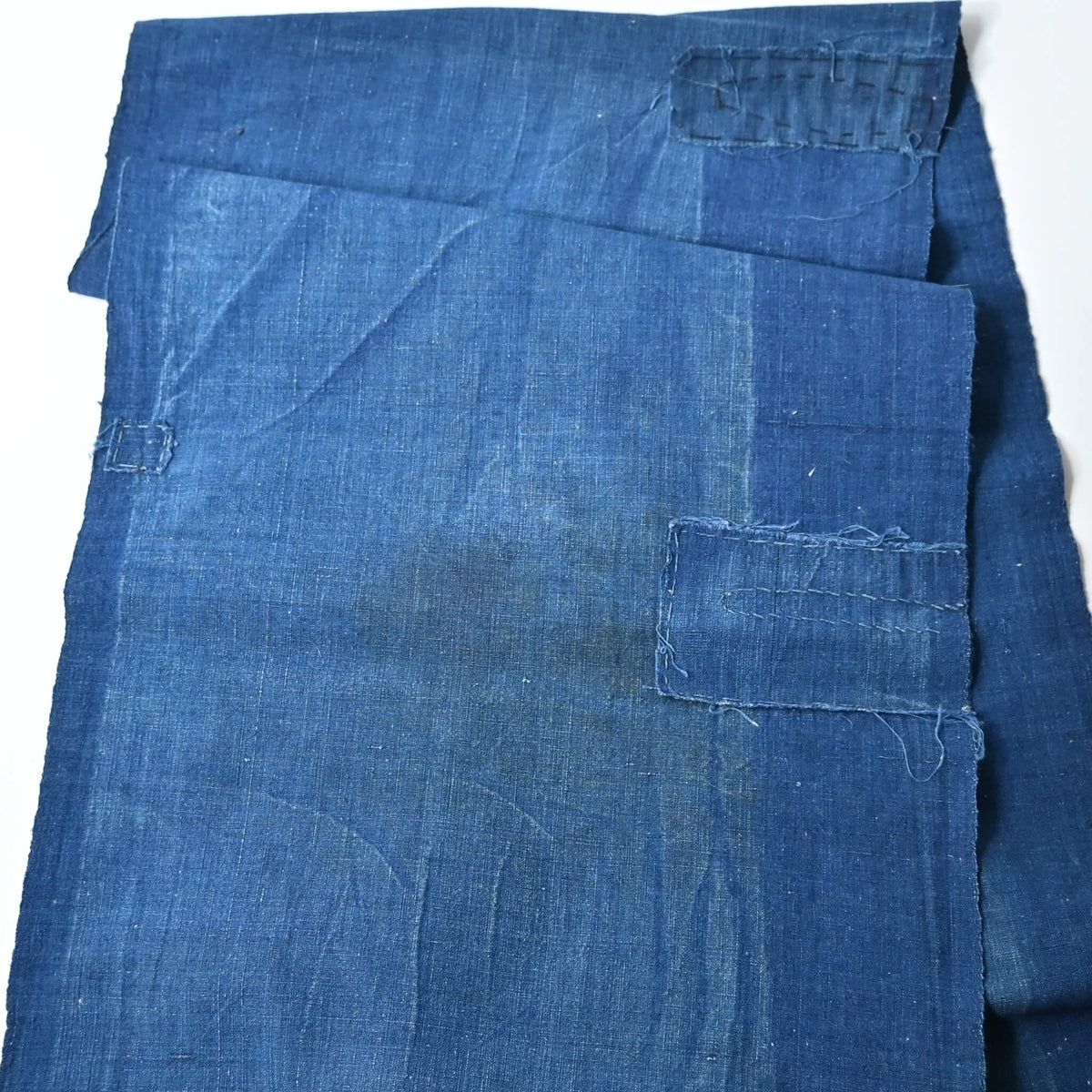 Detailed view of vintage Japanese plain indigo cotton from old kimono with some mends.