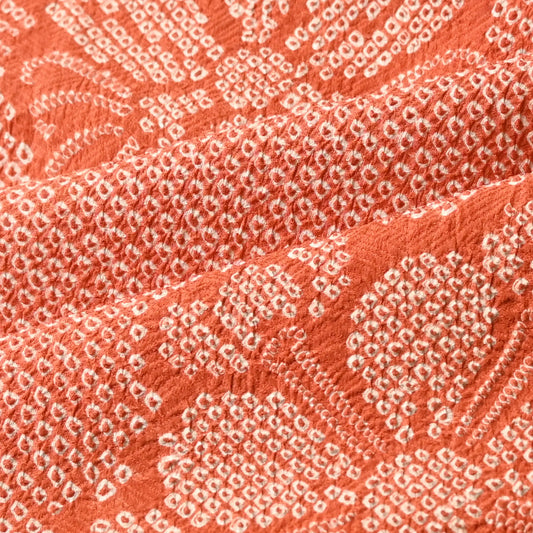 Detailed view of vintage burnt orange shibori silk with a beautiful textured surface.