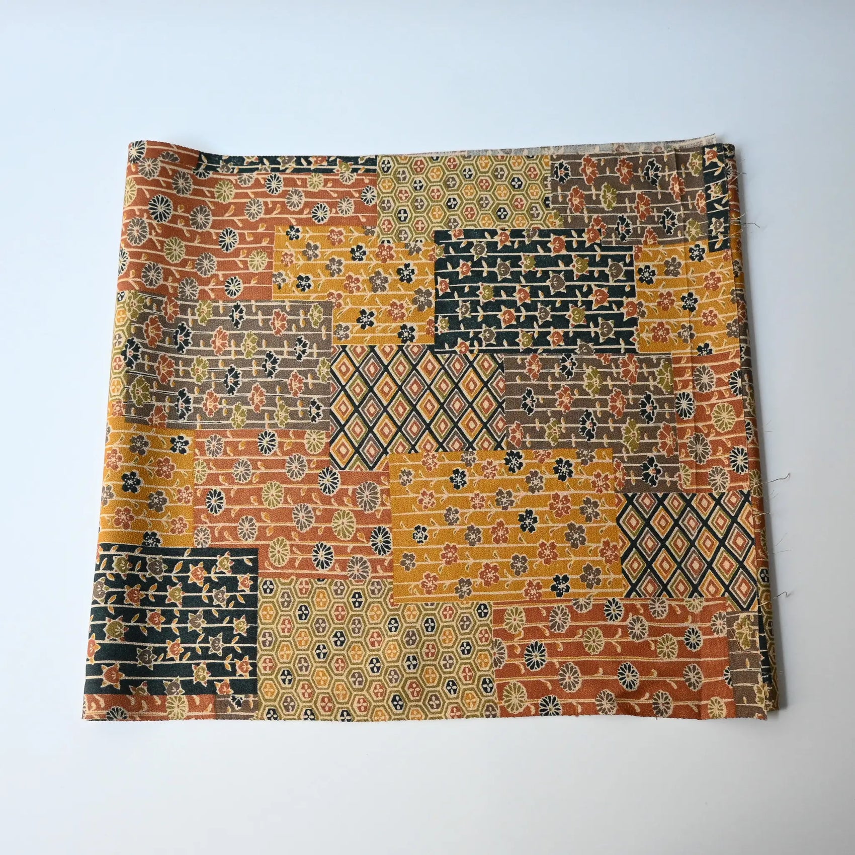 Vintage silk crepe kimono fabric piece, patchwork floral design in a warm colour palette.