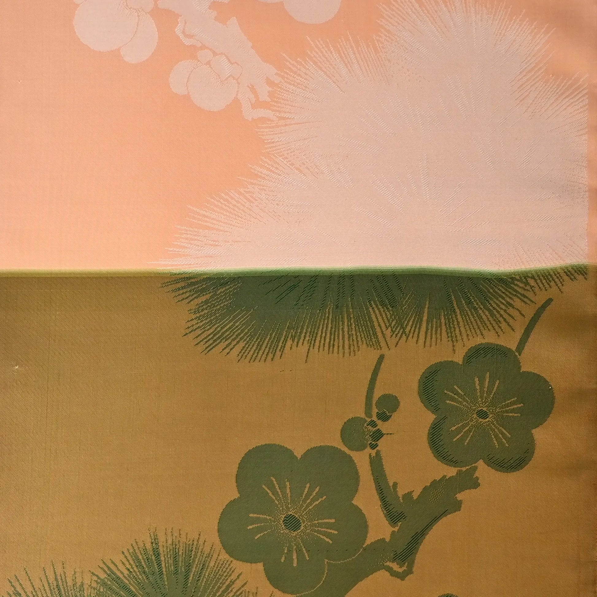 Detailed view of vintage Japanese silk fabric with plum blossom in green.