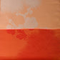 Detailed view of vintage Japanese silk fabric with plum blossom in striking orange.