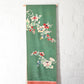 Green Rinzu silk jacquard panel with traditional Japanese seasonal flowers.