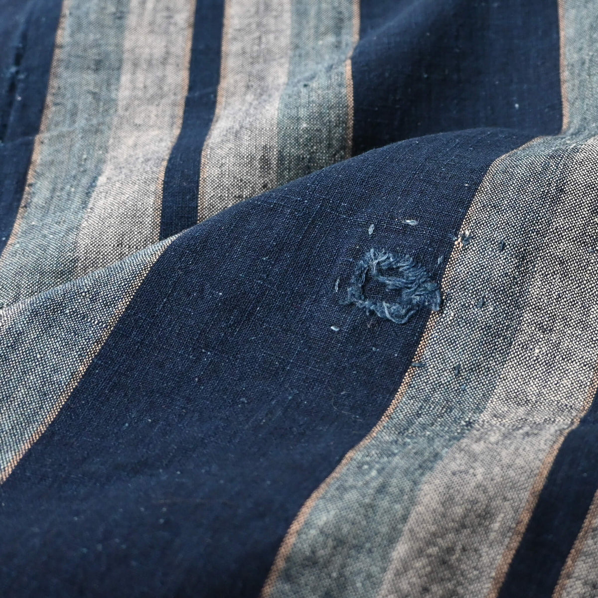 Close-up view of vintage Japanese indigo stripe futon cover with old mends and patches, suitable for boro and patchwork projects