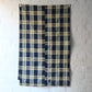 Full view of vintage Japanese indigo and soft yellow check cotton futon cover panel with mended patches.