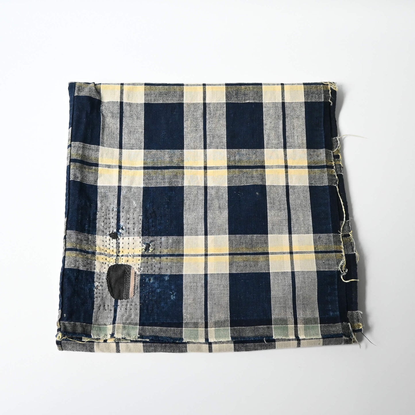Vintage Japanese indigo and soft yellow check cotton futon cover panel with mended patches.
