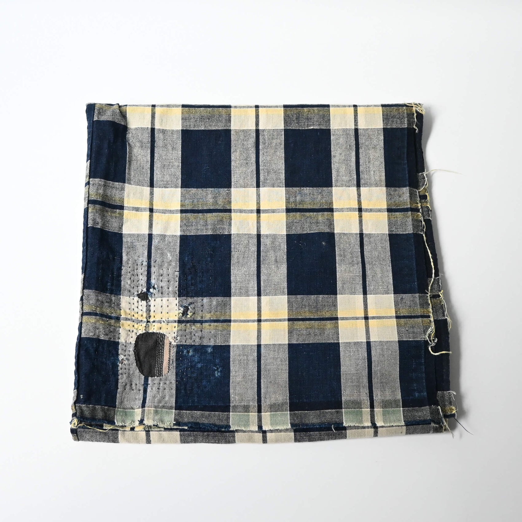 Vintage Japanese indigo and soft yellow check cotton futon cover panel with mended patches.