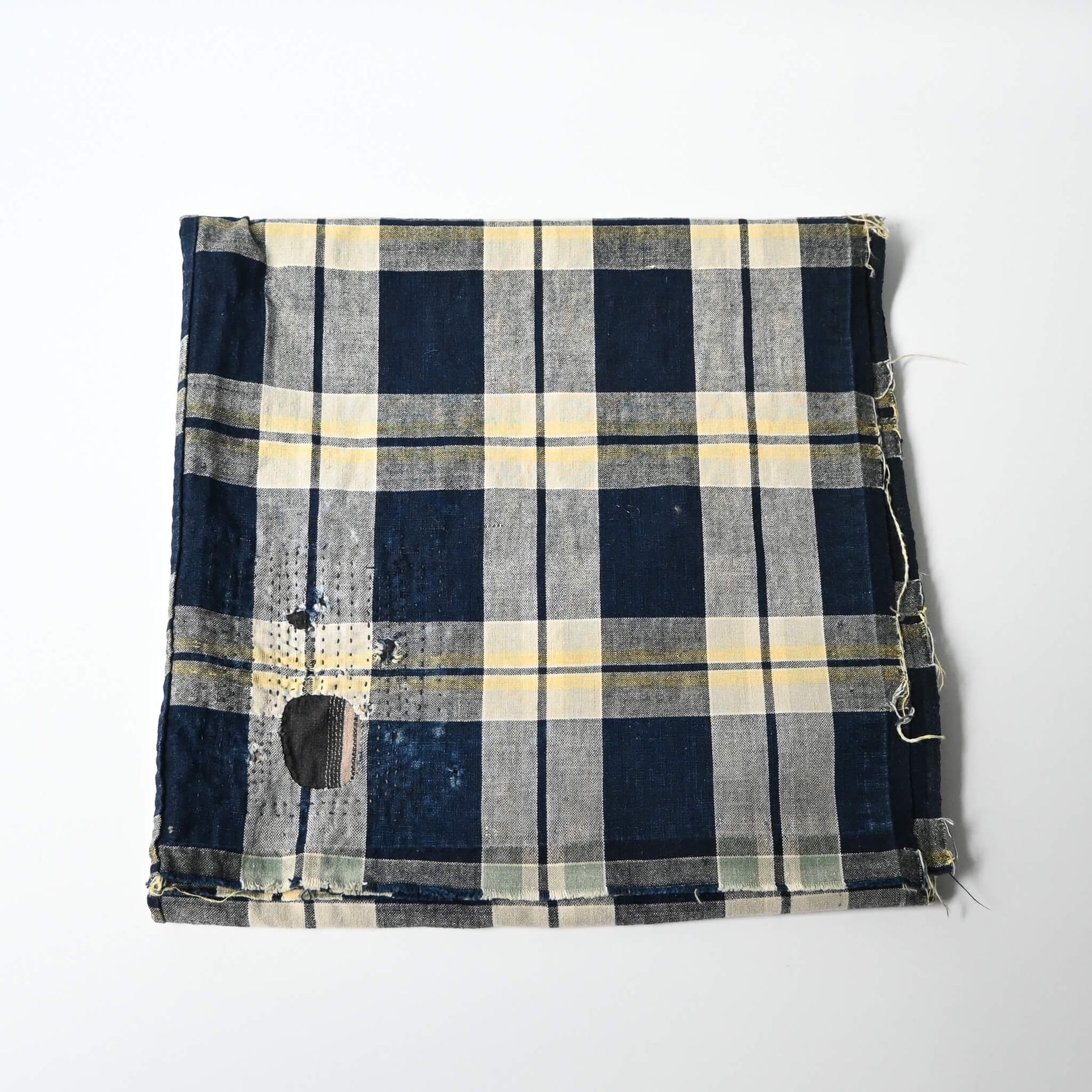 Vintage Japanese indigo and soft yellow check cotton futon cover panel with mended patches.
