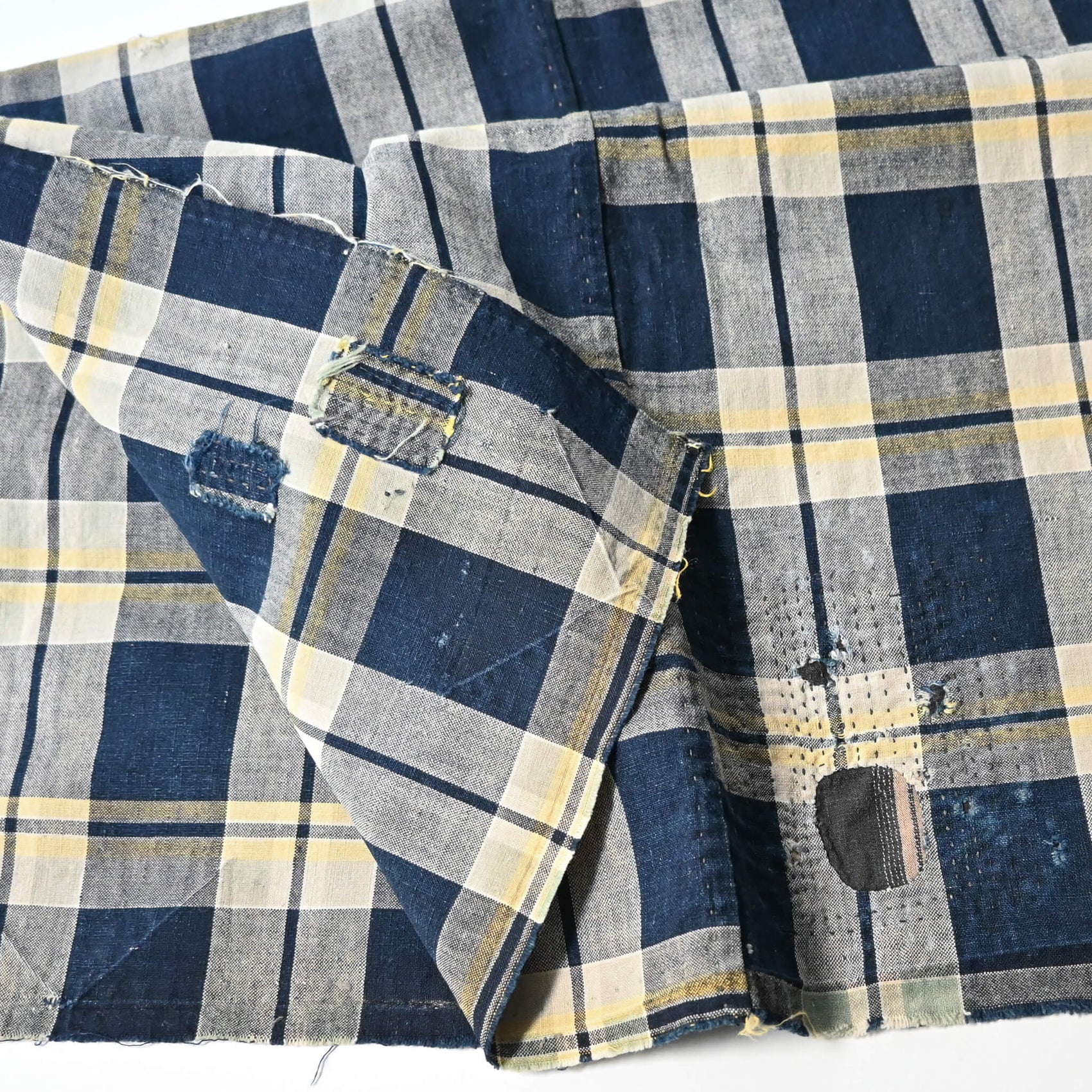 Vintage Japanese indigo and soft yellow check cotton futon cover panel with mended patches.