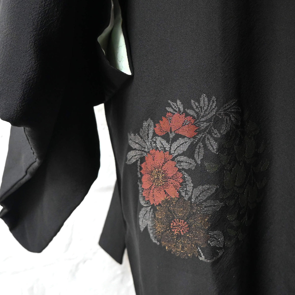 Vintage Japanese women's black silk crepe haori with woven peony design on the back bottom.