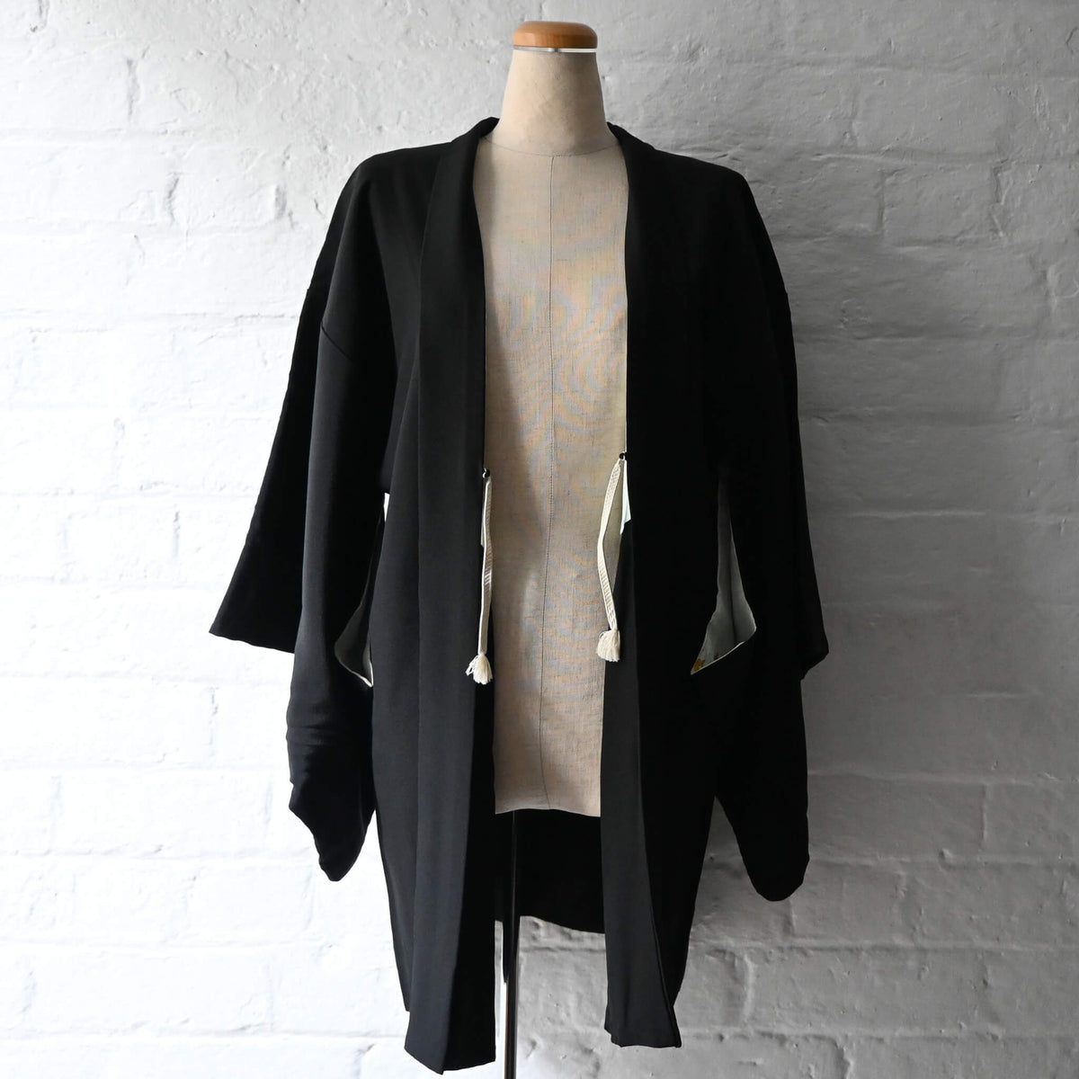 Vintage Japanese women's black silk crepe haori with woven floral motifs.