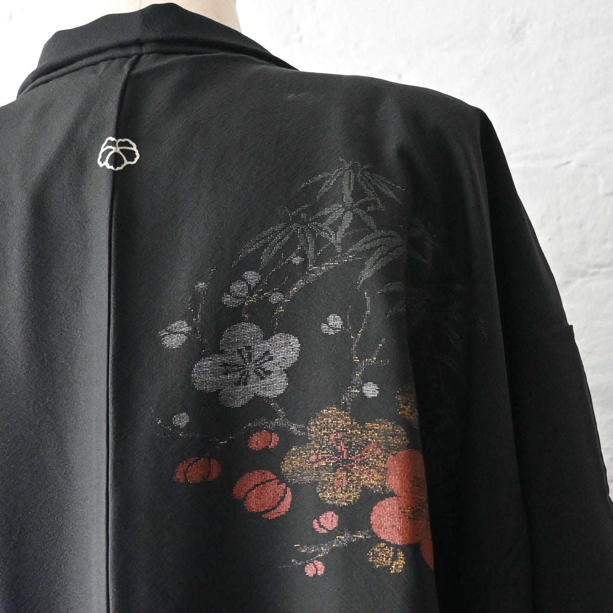 Vintage Japanese women's black silk crepe haori with woven plum blossom design on the back shoulder.