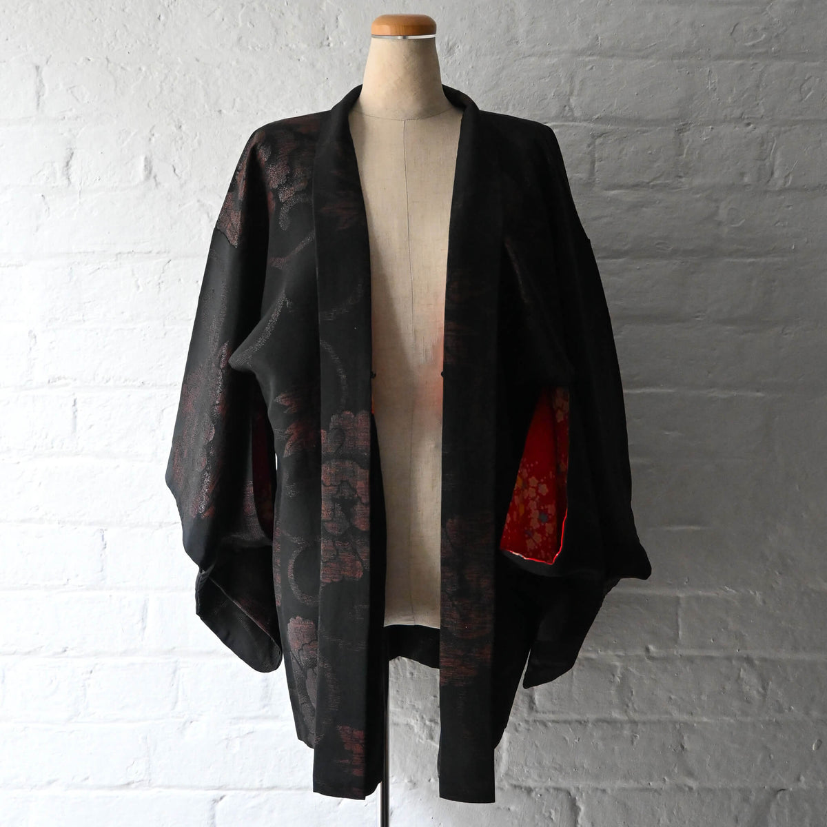 Vintage women's black silk crepe haori with woven peony pattern created with lacquer-coated threads.