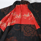 Vintage women's black silk crepe haori with woven peony pattern has a bright red silk lining.