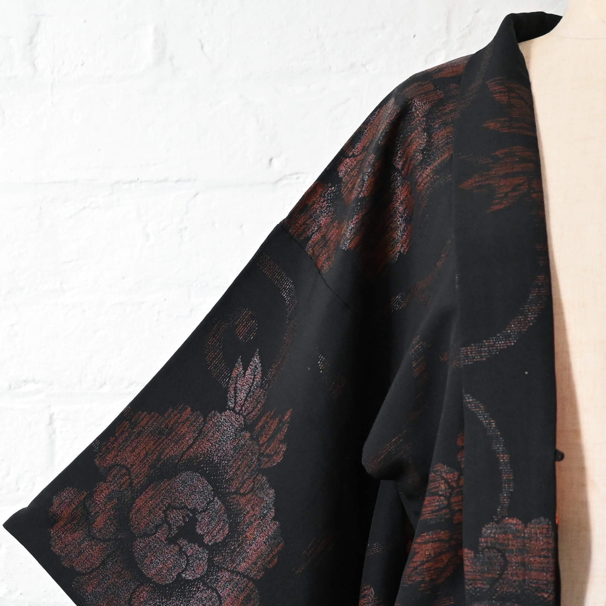 Vintage women's black silk crepe haori with woven peony pattern created with lacquer-coated threads.