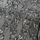 Close-up view of vintage katazome dyed black and white silk crepe with intricate flower and bird motifs.