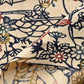 Detailed view of vintage women's silk crepe kimono fabric piece with Katazome stencil dyed seasonal flowers motif.